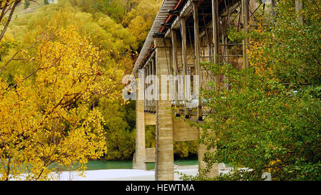 Situated 10 kilometres from Queenstown (off highway 6), the Old Lower Shotover Bridge was built in 1871 and offers foot traffic eye-catching 360 panoramic views of the Shotover River.  The original bridge was washed away in 1878 by flooding but rebuilt by the Public Works Department and re-opened in 1915. The bridge is172 metres long and stands16 metres from bridge to the river below. Stock Photo