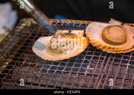 Preparing fresh scallops Tsukiji fish market in Tokyo, Japan Stock Photo
