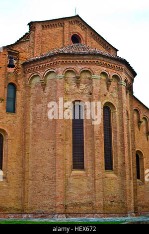 semicircular apse of an ancient Romanesque church brick with hanging arches and stained-glass windows Stock Photo