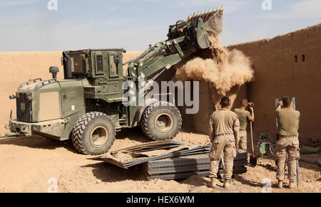 MUSA QALEH, Helmand province, Islamic Republic of Afghanistan – Engineers with 1st Combat Engineer Battalion, 1st Marine Division (Forward), watch a tram vehicle fill a hesco barrier at a small combat outpost in Musa Qaleh, Nov. 4, 2010. Engineers with 1st CEB, were called in to fortify defensive positions manned by 1st Battalion, 8th Marine Regiment. Hesco barriers were set up to replace many of the positions built using sandbags and barbwire. (U.S. Marine Corps photo by Cpl. John M. McCall) Engineers improve 1-8's defense in Musa Qal'eh DVIDS338913 Stock Photo