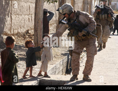 Petty Officer 3rd Class Raul R. Silva, assigned to Police Adviser Team 1 of Headquarters and Service Company, 3rd Battalion, 5th Marine Regiment, interacts with Afghan children during a security patrol with Civil Affairs Group and Afghan Uniformed Police. The battalion is one of the combat elements of Regimental Combat Team 2 conducting counter insurgency operations with the International Security Assistance Forces. (U.S. Marine Corps photo by Lance Cpl. Jorge A. Ortiz) Operation Enduring Freedom DVIDS341530 Stock Photo