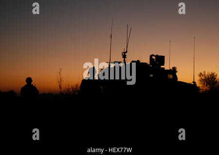 The sun sets on a long day of emplacing a Dry Support Bridge over one of the canals near the village of Hyderabad, Gereshk District, Helmand province, Dec. 3. The combined force totaled more than 350 people and took two days from demolition to construction. The DSB is the first of its kind to be emplaced in Afghanistan. Canal work in the Gereshk District DVIDS351371 Stock Photo