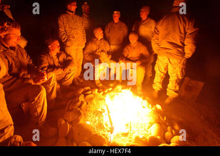 MUSA QAL’EH, Helmand province, Islamic Republic of Afghanistan – Marines with 1st Combat Engineer Battalion, 1st Marine Division (Forward), try to keep warm around a fire at a combat outpost in Musa Qal’eh, Dec. 21, 2010. Engineers endured cold weather regularly when working late nights to improve the defenses of forward operating positions in Musa Qal’eh district. (U.S. Marine Corps photo by Cpl. John M. McCall) Marines work through holidays, bring gift of security to Musa Qal'eh DVIDS358084 Stock Photo