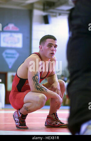 US Marine Corps (USMC) Corporal (CPL) Justin Cannon, a member of the All Marines Wrestling Team, takes a breather during one of his Greco Roman matches during the Armed Forces Wrestling Championship held in New Orleans, Louisiana (LA). Squatting wrestler with tattoos Stock Photo