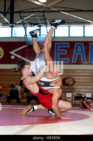 040306-M-7837W-003 New Orleans, La. (Mar. 6, 2004) Ð United States Marines Corps wrestler, Cpl. Jake Clark, in red, takes down United States Navy wrestler Joseph Axiotis to win the gold metal at the 2004 Armed Forces Wrestling Championship held at Archbishop Rummel High School, New Orleans, La. Cpl. Clark wrestles both Greco Roman and Freestyle in the 84K weight class, and is currently training with the U.S. Olympic Team in Colorado Springs, Colo.  Cpl. Clark is hoping to qualify for the 2004 Olympics in Athens, Greece. U.S. Marine Corps photo by Lance Cpl. Lydia L. Collison. (RELEASED) 040306 Stock Photo