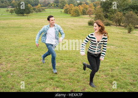 Couple running in field Stock Photo