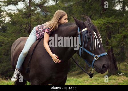 Girl sitting bareback on horse in forest glade, Sattelbergalm, Tyrol, Austria Stock Photo