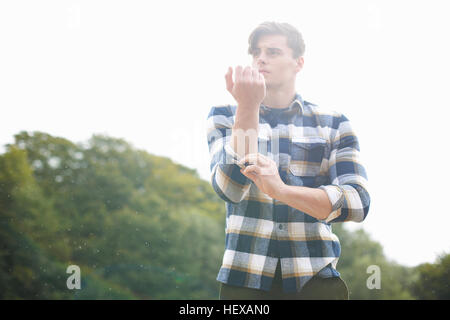 Portrait of man wearing plaid shirt rolling up sleeves Stock Photo
