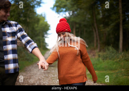 Couple holding hands walking on dirt track Stock Photo