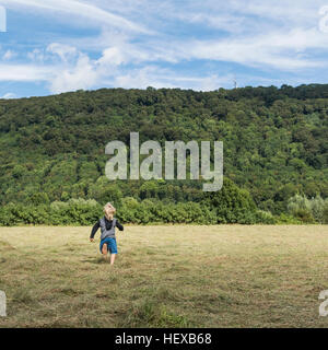 Rear view of boy running in field, Porta Westfalica, North Rhine Westphalia, Germany Stock Photo