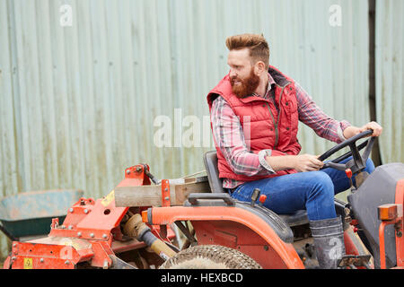 Man on farm driving tractor Stock Photo