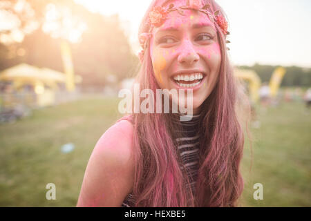 Portrait of young woman at festival, covered in colourful powder paint Stock Photo