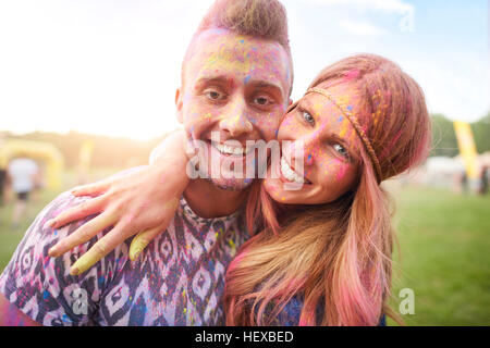 Two friends at festival, covered in colourful powder paint Stock Photo