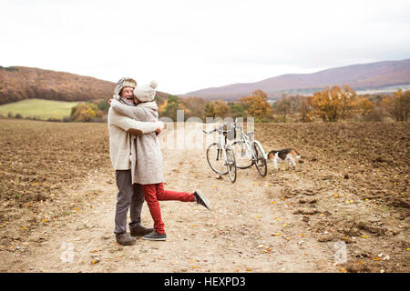 Senior couple doing a bicycle trip with dog Stock Photo