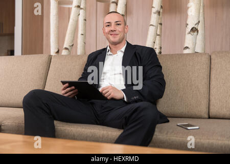 Young Man Working From Home Using Smart Tablet Or Notebook Computer Stock Photo