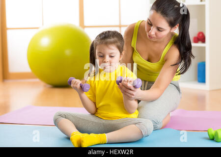 family mother and child daughter are engaged in fitness, yoga, exercise at home or sport hall Stock Photo
