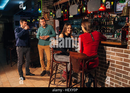 two of the men in the bar he meets  women Stock Photo