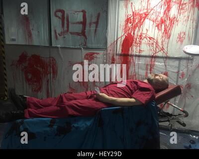 A hospital patient in blood spattered hospital ward during a 2.8 Hours Later zombie game in Cardiff, South Wales. Stock Photo