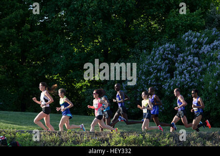 (Ottawa, Canada---24 May 2015) The lead men's pack catches the back of the elite women's lead group racing in the Canadian National 10k Road Champions Stock Photo