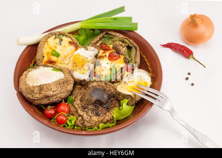 egg and cheese stuffed mushrooms on a plate on a white background Stock Photo