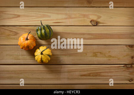 three small pumpkins on the wooden table Stock Photo