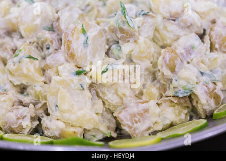 Party food deli buffet - potato salad with chives and mayonnaise with lime slice decoration Stock Photo