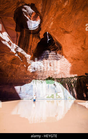 Rappelling into water in The Golden Cathedral with a firefighters belay, Escalante region, Utah Stock Photo