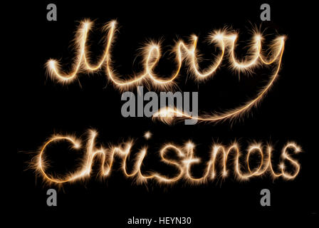 Merry Christmas . Inscription made sparklers on a dark background. Stock Photo