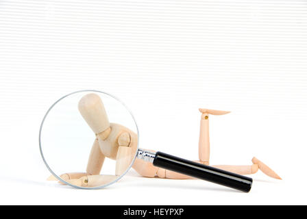 Magnifying glass held over a jointed mannequin: symbol for a transparent person Stock Photo