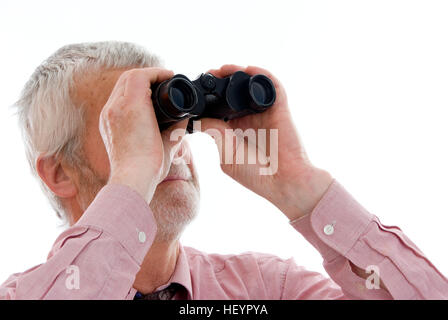 Retiree, senior looking through a pair of binoculars Stock Photo