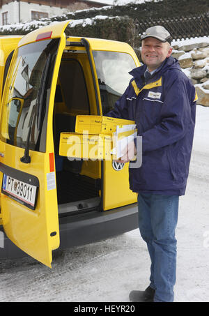 Mailman (Mail carrier, letter carrier) holding packages Stock Photo