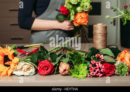 Florist with bouquet of roses at work. Stock Photo