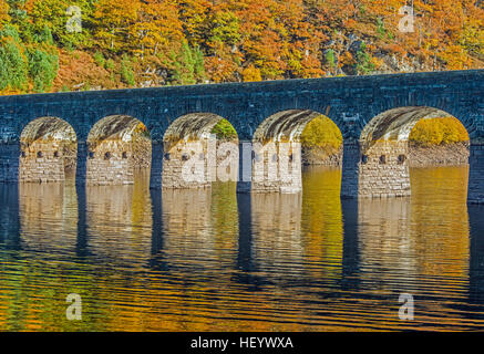 The road bridge Garreg Ddu dam in the Elan Valley Mid Wales with reflection on a bright and sunny autumn day Stock Photo