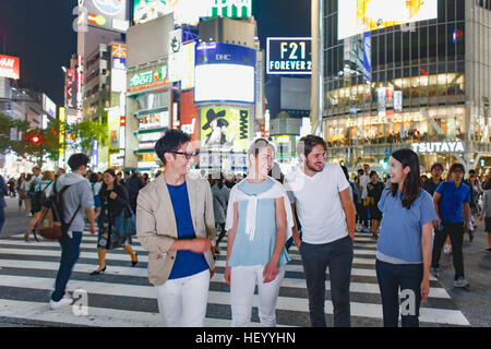 Caucasian couple enjoying sightseeing with Japanese friends in Tokyo, Japan Stock Photo