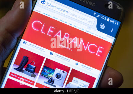 Person holding a mobile phone with the John Lewis clearance sale visible on the screen