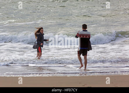 Bournemouth, Dorset, UK. 25th Dec, 2016. UK weather: Choppy seas at the beach - couple take photos of each other paddling in the sea on Christmas day © Carolyn Jenkins/Alamy Live News Stock Photo