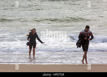 Bournemouth, Dorset, UK. 25th Dec, 2016. UK weather: Choppy seas at the beach - couple take photos of each other paddling in the sea on Christmas day © Carolyn Jenkins/Alamy Live News Stock Photo