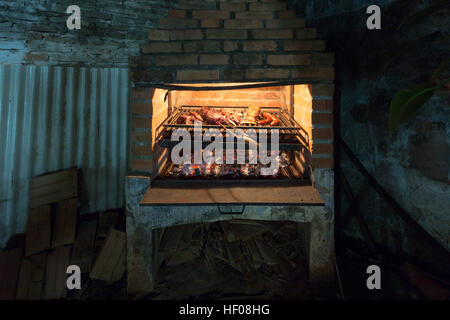 Homemade 'Asado a la parrilla' (Barbecue on the grill), simple barbecue assortment consisting of beef, ribs and sausages on an outdoor grill, Paraguay Stock Photo