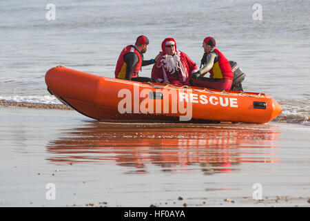 Durley Chine, Bournemouth, Dorset, UK. 26 December 2016. Bournemouth Lifeguard Corps rescue Father Christmas at Durley Chine beach on Boxing Day. The Corps, founded in 1965, is one of the largest and most successful volunteer lifeguard clubs in the UK with more than 100 members aged from 7 to 70. Credit: Carolyn Jenkins/Alamy Live News Stock Photo