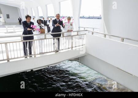 Pearl Harbour, Hawaii. 27th Dec, 2016. U.S President Barack Obama and Japanese Prime Minister Shinzo Abe toss flower petals into the wishing well at the USS Arizona Memorial December 27, 2016 in Pearl Harbor, Hawaii. Abe is the first Japanese leader to publicly view the site of the Pearl Harbor Attack. Credit: Planetpix/Alamy Live News Stock Photo