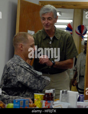 John McHugh, Secretary of the Army, greets Staff Sgt. Joshua Bell, a gunnery sergeant with 1st Battalion, 7th Field Artillery Regiment, 2nd “Dagger” Advise and Assist Brigade, 1st Infantry Division, United States Division – Center, and a Santa Rita, Guam, native, prior to a dinner between McHugh and several soldiers from around USD-C, including two Dagger Brigade soldiers, Sept. 14, 2011, at Camp Liberty, Iraq. During the dinner, McHugh took the opportunity to answer questions and concerns of the soldiers present, including the proposed new retirement system. Secretary of the Army talks issues Stock Photo