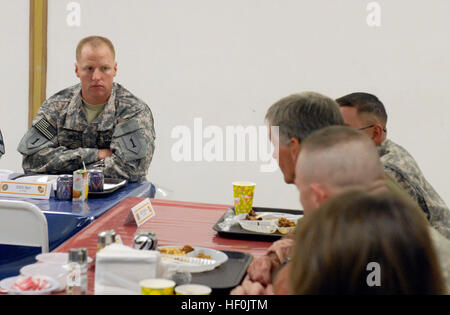 Staff Sgt. Joshua Bell, a gunnery sergeant with 1st Battalion, 7th Field Artillery Regiment, 2nd “Dagger” Advise and Assist Brigade, 1st Infantry Division, United States Division – Center, and a Santa Rita, Guam, native, listens to John McHugh (third from bottom), Secretary of the Army, during a dinner between McHugh and several soldiers from around USD-C, including two Dagger Brigade soldiers, Sept. 14, 2011, at Camp Liberty, Iraq. During the dinner, McHugh took the opportunity to answer questions and concerns of the soldiers present, including the proposed new retirement system. Secretary of Stock Photo