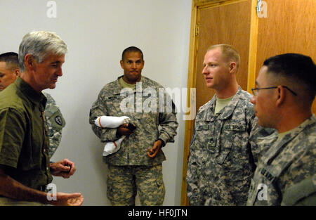 John McHugh (left), Secretary of the Army, speaks with Staff Sgt. Joshua Bell, a gunnery sergeant with 1st Battalion, 7th Field Artillery Regiment, 2nd “Dagger” Advise and Assist Brigade, 1st Infantry Division, United States Division – Center, and a Santa Rita, Guam, native, following a dinner between McHugh and several soldiers from around USD-C, including two Dagger Brigade soldiers, Sept. 14, 2011, at Camp Liberty, Iraq. During the dinner, McHugh took the opportunity to answer questions and concerns of the soldiers present, including the proposed new retirement system. Secretary of the Army Stock Photo