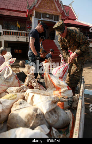 Lance Cpl. Christopher J. Brown, satellite operator, III Marine Expeditionary Force Flood Relief Command Element, loads bags full of collected trash and debris onto a truck for disposal at a local temple here Nov. 21. In coordination with the U.S. Embassy in Bangkok and the Royal Government of Thailand, U.S. Pacific Command directed theater service components to conduct joint operations in support of disasters assessment and relief operations in Thailand. III Marine Expeditionary Force sent a Flood Relief Command Element consisting of Marines and sailors from Okinawa, Japan, which provide comm Stock Photo