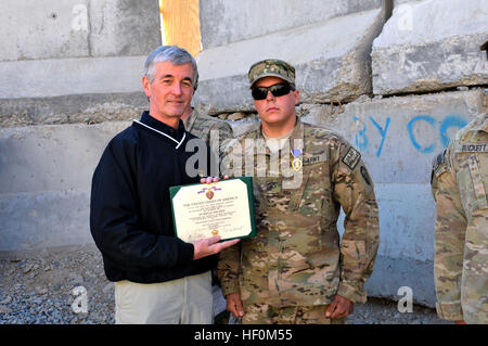 Secretary of the Army John M. McHugh presents the Purple Heart to Grand Junction, Colo. native Pfc. Colby Hargrave, an infantryman with 1st Battalion, 5th Infantry Regiment, in a ceremony at Forward Operating Base Masum Ghar Dec. 14. Secretary of the Army visits Panjwa'i, Afghanistan 111214-A-AX238-005 Stock Photo