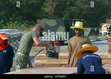 050111-M-3377M-111 Utapao, Thailand - Lance Cpl. Jeffrey Gavlik, left, and civilian construction workers work together to build a walkway in the city of Utapao, Thailand. Gavlik is a combat engineer currently assigned to Combined Support Force Five Three Six (CSF-536) in support of Operation Unified Assistance, the humanitarian operation effort in the wake of the Tsunami that struck South East Asia. U.S. Marine Corps photo by Staff Sgt. Keith L. Myrick (RELEASED) US Navy 050111-M-3377M-111 Lance Cpl. Jeffrey Gavlik, left, and civilian construction workers work together to build a walkway in th Stock Photo