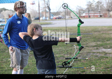 A child prepares to shoot a target at Tarawa Terrace Community Center March 8 during Outdoor Adventure's After School Archery Program. The After School Archery Program was created by the National Field Archery Association. Kids take aim with after school archery program 120308-M-IY869-089 Stock Photo