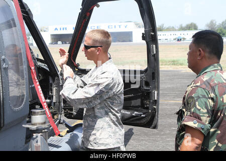 U.S. Air Force Staff Sgt. Robert P. Jarvis, a fire protection crew chief from the 18th Civil Engineering Squadron, discusses helicopter rescue procedures with Philippine Air Force Tech Sgt. Manuel L. Galve Jr., a fire protection chief for the 6012th Base Operations Squadron, during Exercise Balikatan 2012 here April 16. Fire protection teams kick off Balikatan 2012 120416-M-FF989-004 Stock Photo