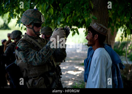 U.S. Marine Corps Lance Cpl. Matthew Curtis, a rifleman with 4th Squad, 1st Platoon, Delta Company, 1st Battalion, 7th Marine Regiment, Regimental Combat Team 6, uses a Hand-held Interagency Identity Detection Equipment System to record biometrics from a local national while on patrol in Sangin, Helmand province, Afghanistan May 1, 2012. Marines patrolled to provide security in the area and interact with the local populace. (U.S. Marine Corps photo by Sgt. Logan W. Pierce/Released) Patrolling in Sangin 120501-M-EU691-080 Stock Photo