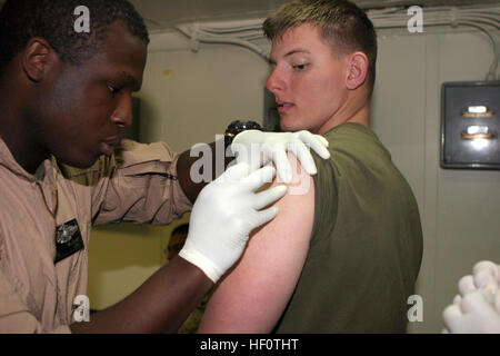 050422-M-5900L-005 Mediterranean Sea (April 22, 2005) - Hospital Corpsman 2nd Class James S. Williams, assigned to Marine Medium Helicopter Squadron One Six Two (HMM-162), gives a Small Pox shot to a Marine aboard the amphibious assault ship USS Kearsarge (LHD 3).  Marines assigned to the 26th Marine Expeditionary Unit keep up to date with immunization to ensure combat readiness during their deployment in support of the Global War on Terrorism. U.S. Marine Corps photo by Lance Cpl. Daniel R. Lowndes (RELEASED) US Navy 050422-M-5900L-005 Hospital Corpsman 2nd Class James S. Williams, assigned t Stock Photo